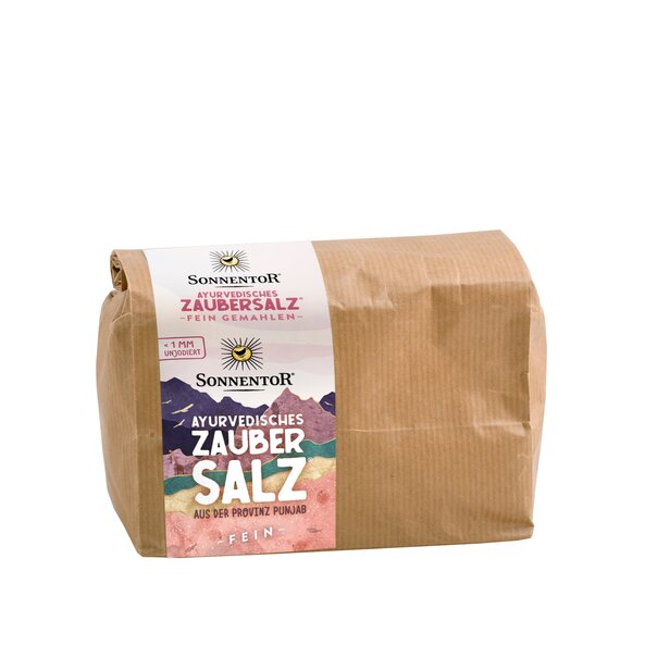 Photo of a gianz-size pack ayurveda magic salt. On it you can see colorful mountains. Through a small window you can see the pink salt.